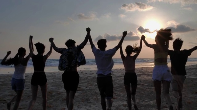 一群朋友在海滩上玩耍的剪影。快乐微笑的朋友们跑步海边海边海边度假旅游。假期——iStock视频下载