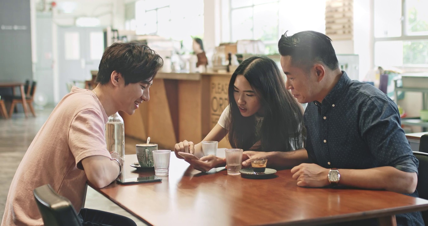 一名中國女子在自助餐廳用手機和朋友分享社交媒體視頻素材