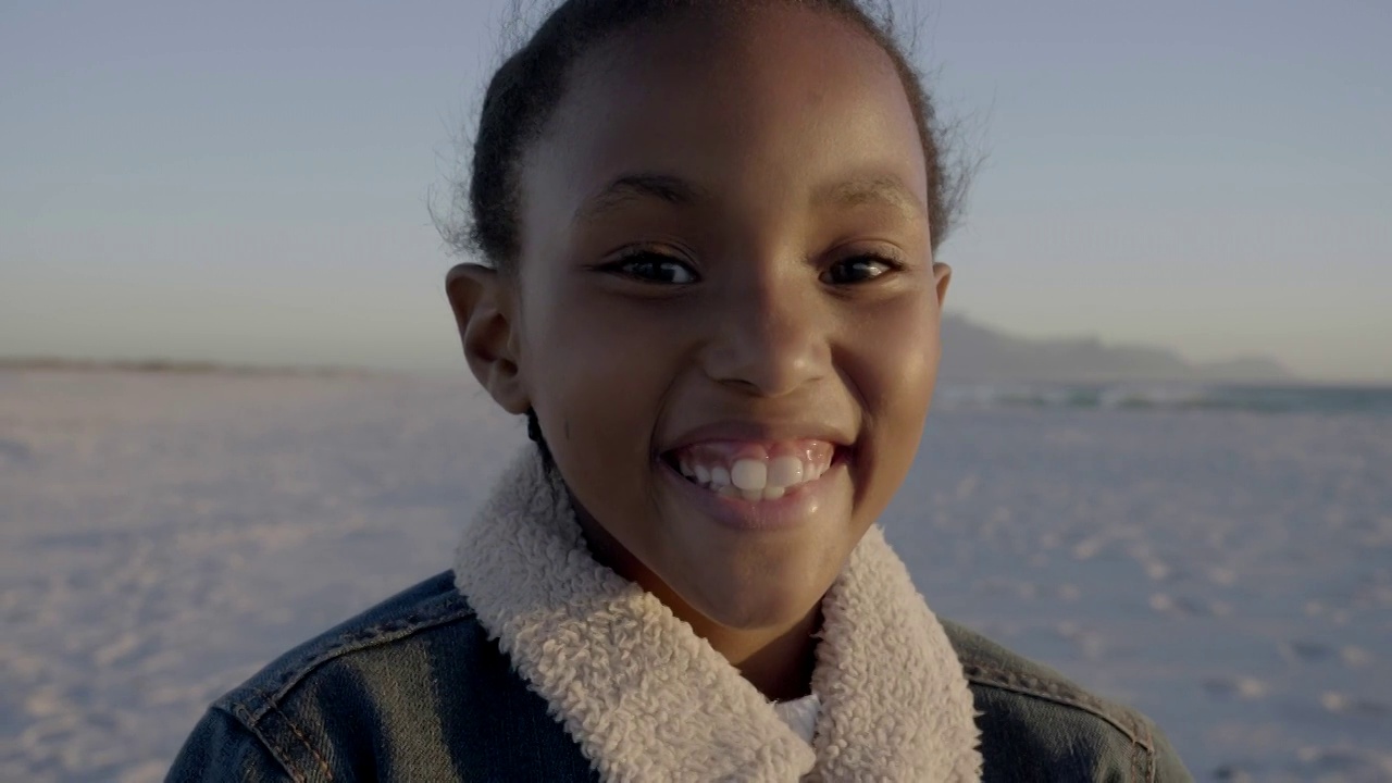 微笑的女孩穿着牛仔夹克在海滩在夏天视频下载