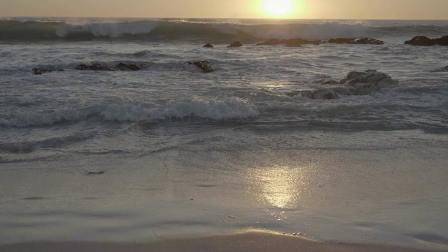 日落时海浪冲向海滩视频购买