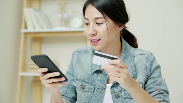 有魅力的亚洲女人用信用卡支付手机视频素材