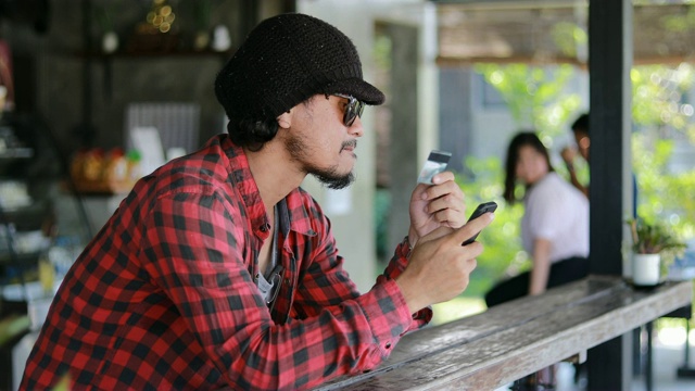 亚洲男子与背包旅行者使用智能手机进行视频通话和拍照视频下载