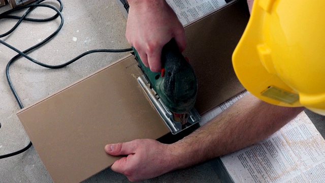熟练工人用电锯锯木层压板。视频下载