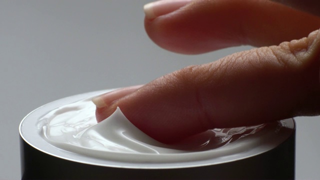 手触摸霜保湿产品的特写。视频下载