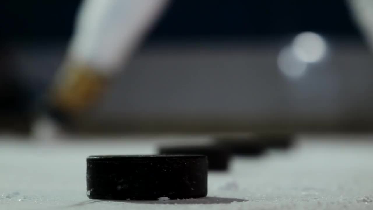 冰上冰球的特写镜头，冰球运动员用慢动作击打冰球视频购买