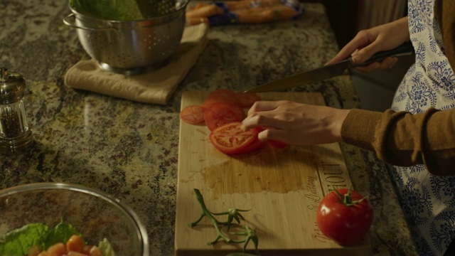 高角度近距离观看妇女的手切片西红柿沙拉在厨房/雪松山，犹他州，美国视频素材
