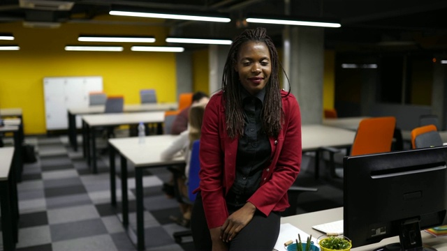 年轻的非洲女企业家坐在她的桌子上视频素材
