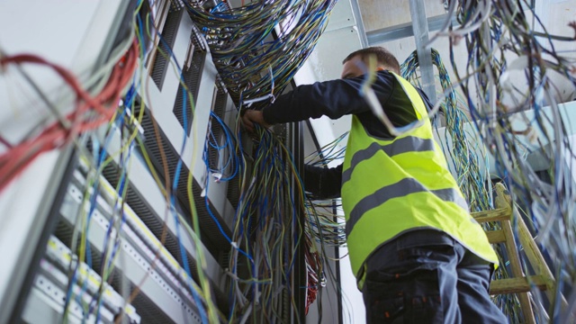 电工在一个新的交流机箱中组织电线视频素材