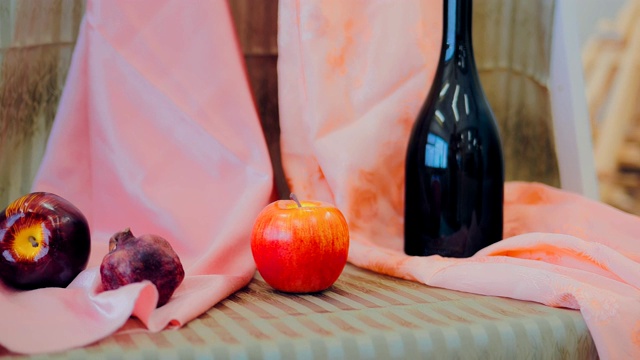 桌上放着苹果和一个瓶子，这是艺术家的自然静物画。特写镜头。视频下载