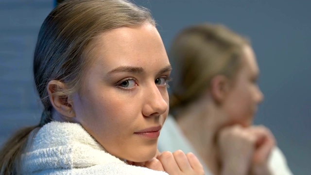 美丽的女性青少年应用面霜，美容护理年轻的皮肤视频素材