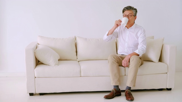 老男人坐在沙发上喝咖啡视频下载