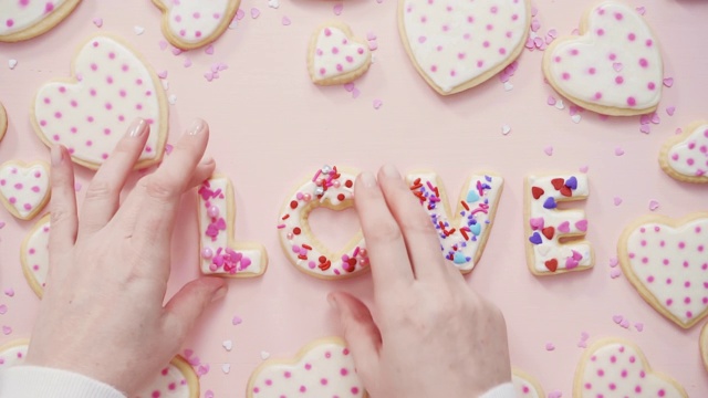 在粉红色的背景上点缀着皇家糖霜的糖饼干。视频素材