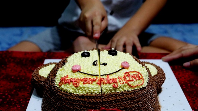孩子在他的生日聚会上愉快地切蛋糕视频下载
