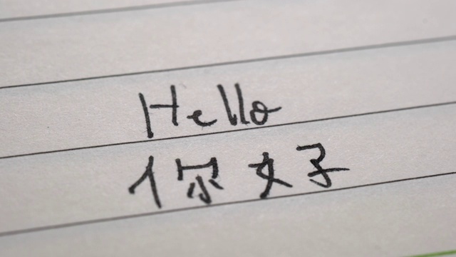 初学汉语的人在笔记本上用汉字和拼音写“你好”和“你好”视频素材