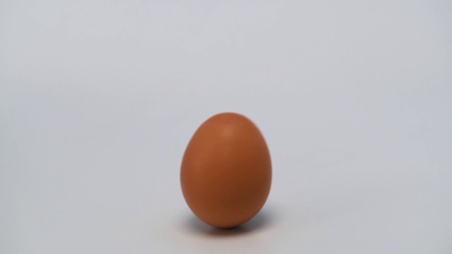 鸡蛋移动和滚动在白色的背景视频下载
