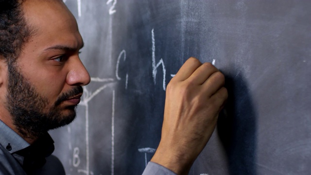 男教授在黑板上写数学公式视频素材
