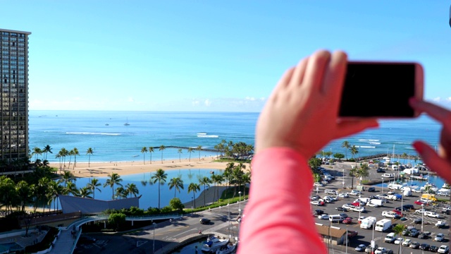 一名女子在拍摄夏威夷怀基基海滩的4K慢镜头视频下载
