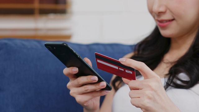 近距离的妇女持有信用卡和数字平板电脑支付网上购物在家，电子商务，网上银行视频素材