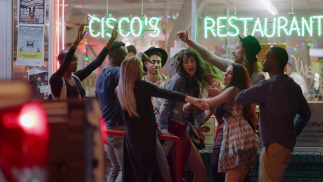 在德克萨斯州奥斯汀市的一家市中心餐厅外，一群年轻的多样化朋友又跳又唱。视频购买