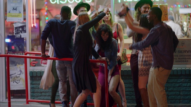 各种各样的潮人朋友在奥斯汀市中心的街角跳舞，汽车在前景。视频购买