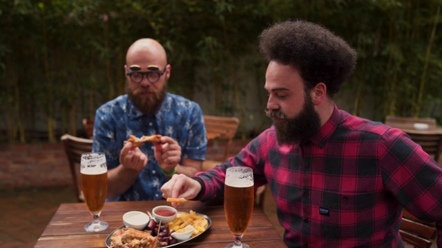 男性朋友喜欢吃鸡翅和啤酒视频素材