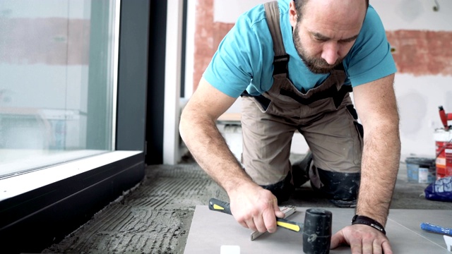 铺砖机用木槌调整新安装的瓷砖视频素材