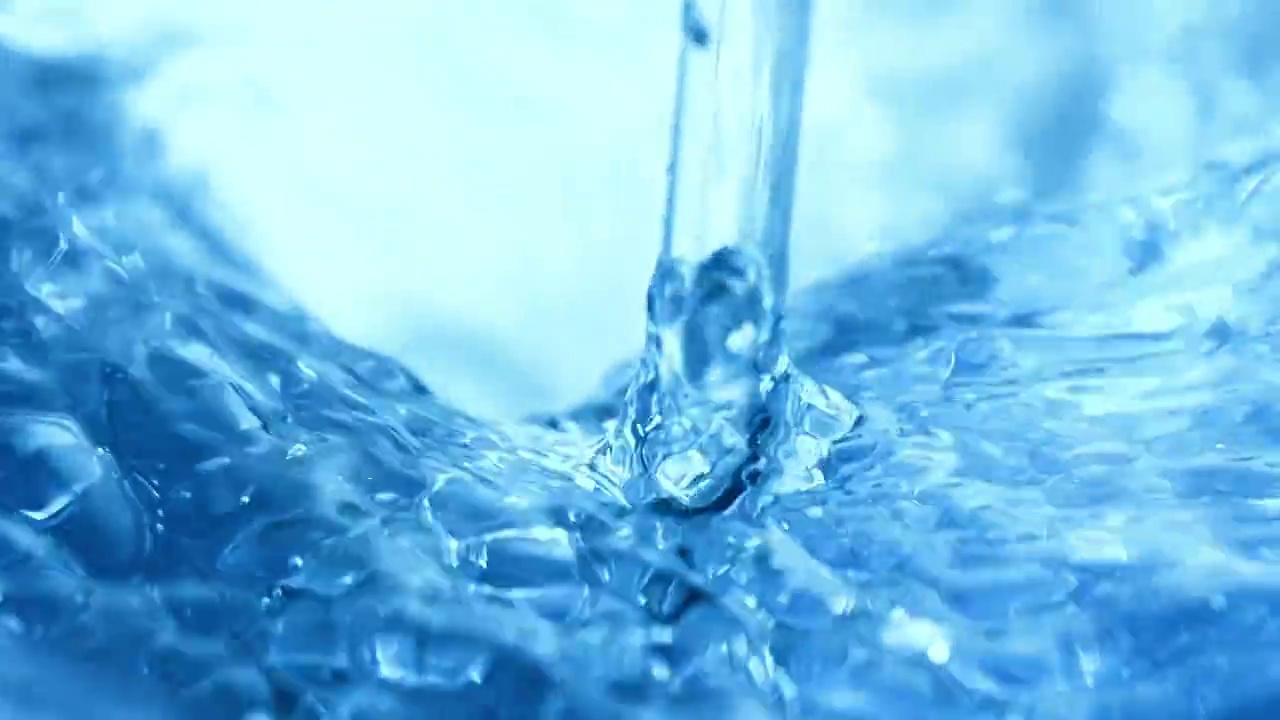 用玻璃棒搅拌蓝色的水，做出波浪和siwrls，在近距离和缓慢的动作视频下载