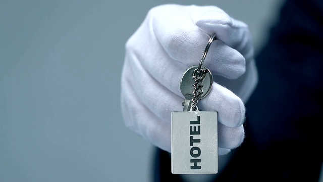 酒店字上钥匙链在男门卫手中，友好的豪华度假村服务视频下载