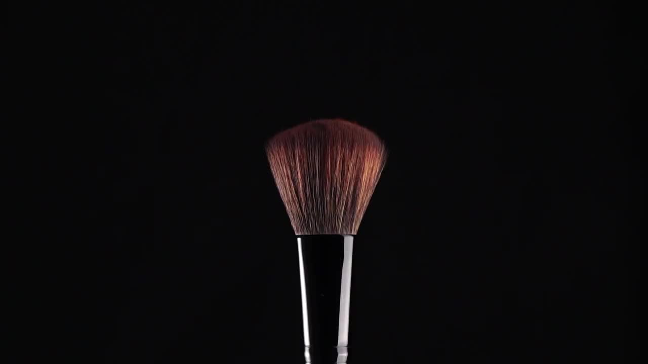 慢镜头:化妆刷和红色粉末爆炸视频素材