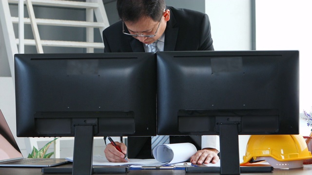 亚洲商人在办公室使用笔记本电脑。视频下载