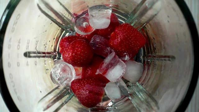 在搅拌机中准备草莓。缓慢的运动。视频下载