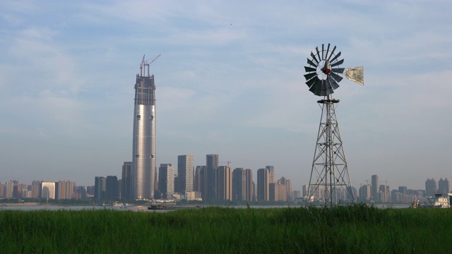 多叶片风力泵在中部汉口沼泽和武汉城市天际线的背景在中国湖北视频下载