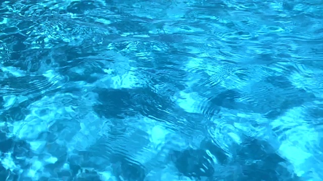水池清澈的水纹理和阳光的光线。慢动作的背景视频素材