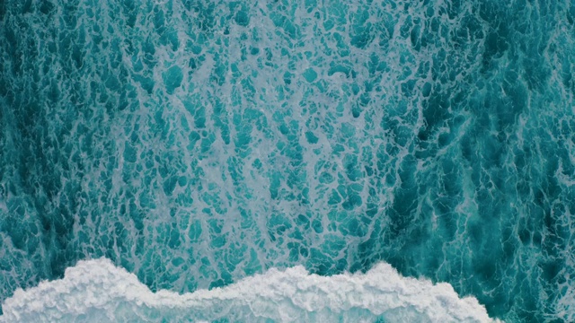 鸟瞰图，海浪沿着海岸拍打成泡沫视频下载