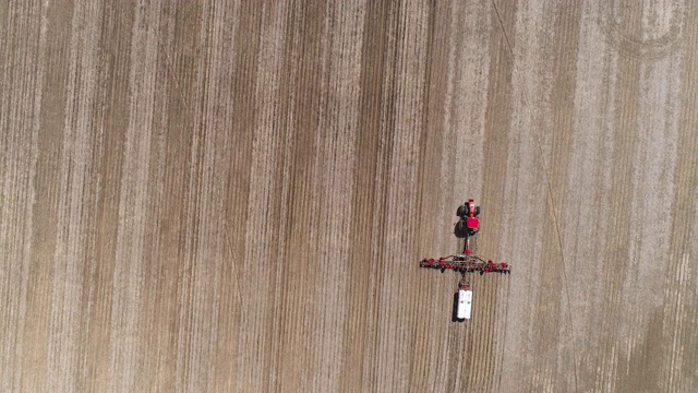 美国伊利诺斯州林登镇附近，拖拉机在春耕和施肥。无人机视频与平移摄像机运动。视频下载