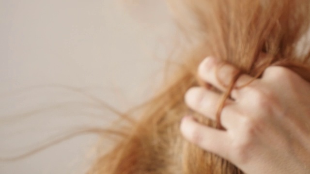 金发女人慢动作用吹风机吹彩色头发视频素材