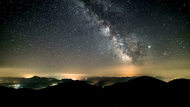 山间星夜时光流逝。银河系恒星在乡村交通上移动。晚上天视频素材