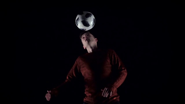 慢镜头，足球运动员头顶球耍把戏。特写镜头视频素材