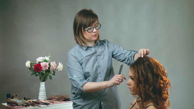 发型师在时尚沙龙为美女梳头。女人结婚视频素材