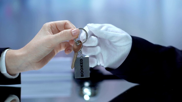 接待员将预订的钥匙链传递给客户、酒店业务、接待人员视频下载