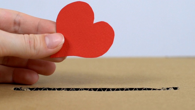 手把纸心脏放在纸箱里，帮助心脏病患者视频下载