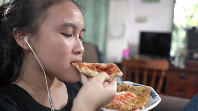 亚洲女孩吃披萨视频素材
