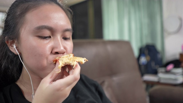 亚洲女孩吃披萨视频素材