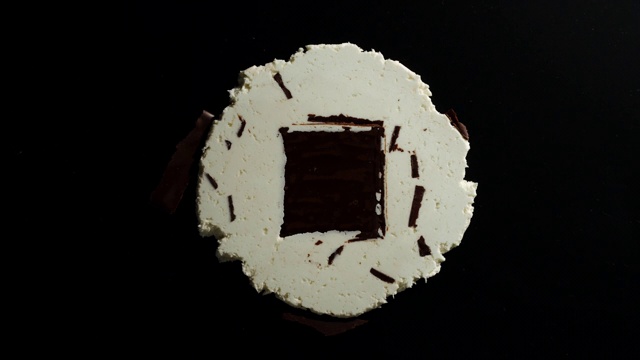 在黑色背景下碾碎整个巧克力蛋奶酥糖果视频下载