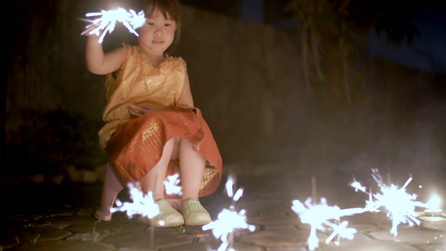小女孩在泰国服装扮演一个闪闪发光的水灯节视频素材