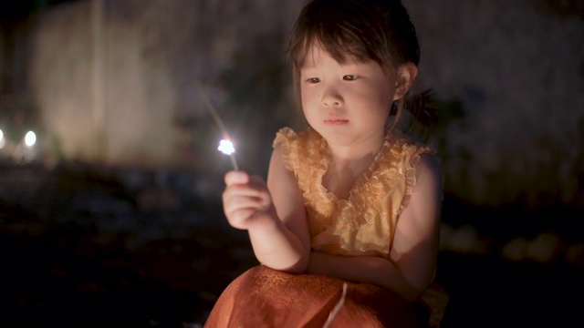 小女孩在泰国服装扮演一个闪闪发光的水灯节视频素材