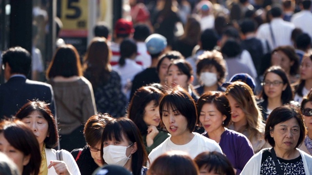 一群通勤者在东京用背光行走视频素材