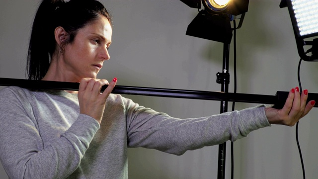 女性摄影师与相机滑块附近的LED菲涅耳和LED面板灯视频下载
