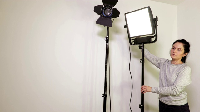 女摄影师靠近LED菲涅耳和LED面板灯视频下载
