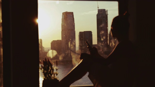 女人在家享受紐約的日落視頻素材